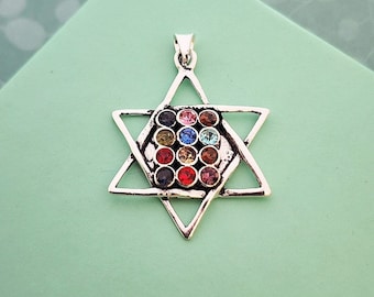 May include: A silver Star of David pendant with a colorful crystal design. The pendant features a six-pointed star with a smaller star inside, adorned with a variety of colored crystals.