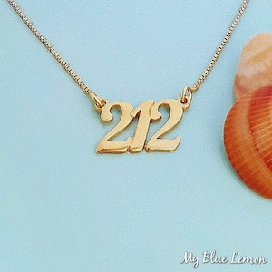 Könnte beinhalten: Eine goldene Halskette mit einem Anhänger, auf dem "212" steht.