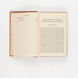 May include: An open book titled "Selections from the Prose Works of Emerson" with a red cover. The left page displays the table of contents, while the right page shows the introduction. The pages are cream-colored.