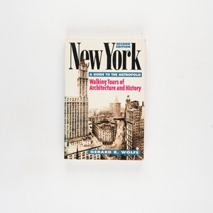 May include: A book titled "New York" with a cityscape illustration on the cover. The cover text includes "A Guide to the Metropolis" and "Walking Tours of Architecture and History." The book is a second edition by Gerard R. Wolfe.