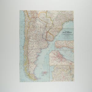 Puede incluir: Un mapa antiguo y detallado de Sudamérica, con información geográfica. El mapa presenta un océano azul claro y masas terrestres coloridas, impreso en papel envejecido. El título "South America" es visible, junto con el logotipo de National Geographic Magazine.