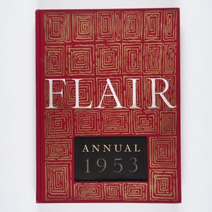 May include: A red book titled "FLAIR ANNUAL 1953." The cover features a gold geometric pattern and the title in large white letters. The year is displayed on a black rectangular label.