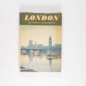 Pode incluir: Um livro vintage intitulado "Londres" de Martin Hurlimann, com uma ilustração em aquarela do Palácio de Westminster e o Big Ben com barcos no Rio Tâmisa.
