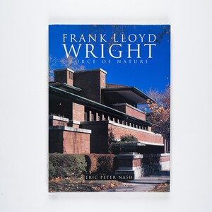 May include: Book cover featuring a photograph of a brick building with a blue sky in the background. The title of the book is "Frank Lloyd Wright Force of Nature" and the author is "Eric Peter Nash".