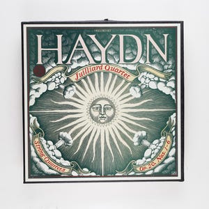 May include: A vintage record album cover featuring a green and gold illustration of a sun with a face, surrounded by clouds and ribbons. The text on the cover reads "HAYDN, Juilliard Quartet, String Quartets, Op. 20, Nos. 1-6".