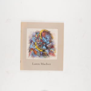 May include: A book cover with an abstract painting in shades of blue, yellow, and red, set within a beige border. The name "Loren MacIver" is printed below the artwork. The overall design is artistic.