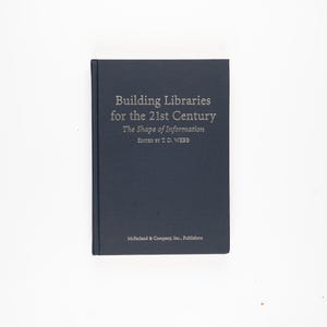 Puede incluir: Un libro de tapa dura azul oscuro titulado "Building Libraries for the 21st Century" con el subtítulo "The Shape of Information". El texto es plateado. El nombre del editor está en la parte inferior.