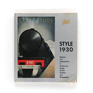 May include: Book cover with a black and white illustration of a train engine with the word "ETAT" on the side. The title of the book is "STYLE 1930" and the subtitle is "Elegance and Sophistication in Architecture, Design, Fashion, Graphics and Photography."