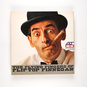 May include: Vintage album cover featuring a man in a black bowler hat, bow tie, and a cigar. The album title, "The Flying Fingers of Flip Top Finnegan," is printed at the bottom. The man has a surprised expression.