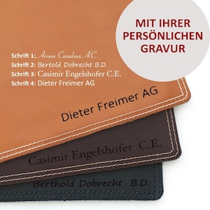 Pode incluir: Quatro amostras de couro com diferentes fontes e nomes gravados nelas. O texto diz: "Schrift 1: Ariane Casadina A.C. Schrift 2: Bertold Dobrecht B.D. Schrift 3: Casimir Engelshofer C.E. Schrift 4: Dieter Freimer AG" e "MIT IHRER PERSÖNLICHEN GRAVUR Dieter Freimer AG Casimir Engelshofer C.E. Berthold Dobrecht B.D."