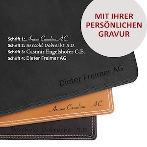 Könnte beinhalten: Nahaufnahme von vier übereinander gestapelten Leder-Schreibtischunterlagen. Die oberste Unterlage ist braun und trägt den Text "Ariane Casadina A.C." in kursiver Schrift. Die zweite Unterlage ist schwarz und trägt den Text "Berthold Dobrecht B.D." in einer Serifenschrift. Die dritte Unterlage ist braun und trägt den Text "Dieter Freimer AG" in einer serifenlosen Schrift. Die unterste Unterlage ist schwarz und trägt den Text "MIT IHRER PERSÖNLICHEN GRAVUR" in einer fetten serifenlosen Schrift.