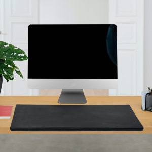 May include: A black leather desk mat on a wooden desk in front of a computer monitor.