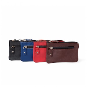 Può includere: Quattro piccoli porta monete in pelle con chiusura a zip. I porta monete sono in nero, blu, rosso e marrone.