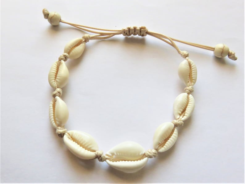 ecru cowries adjustable bracelet bracelet wrist or ankle or black cord beads at the ends. shells