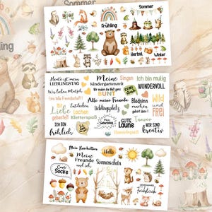 Könnte beinhalten: Drei rechteckige Aufkleberbögen mit Aquarellillustrationen von Waldtieren, Bäumen, Pilzen und saisonalen Motiven. Die Designs enthalten deutsche Textphrasen, Regenbögen sowie Waldtiere wie Bären, Füchse und Hasen in verschiedenen Posen.