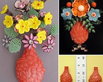 May include: A collection of vintage floral brooches. One brooch features a vase with yellow, pink, and white flowers. Another brooch has orange and blue flowers. The third image shows two small, red vases, each approximately 2 inches tall.