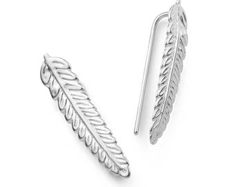 May include: A pair of silver feather earrings. The earrings are made of a thin metal and have a delicate, feather-like design.