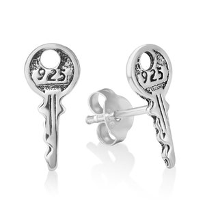 Puede incluir: Un par de pendientes de plata en forma de llave con el número "925" grabado en la cerradura.
