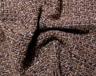Op de afbeelding: Close-up van een bruine en witte tweed stof met een textuur, geweven patroon.