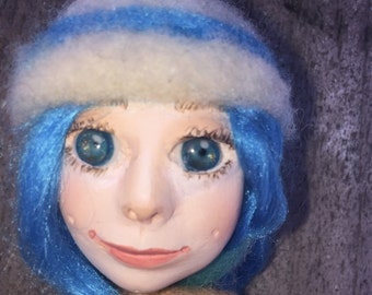 Blue haired doll with a posable body.