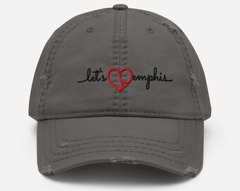 Può includere: Un berretto da baseball grigio consumato con il testo "Let's love Memphis" ricamato in nero con un cuore rosso.