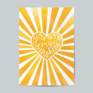 May include: A yellow watercolor sunburst with a white heart in the center. The heart has the text "You are my sunshine" written inside.