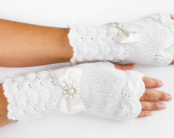 May include: A pair of white fingerless gloves with a satin bow and pearl embellishment on each glove.