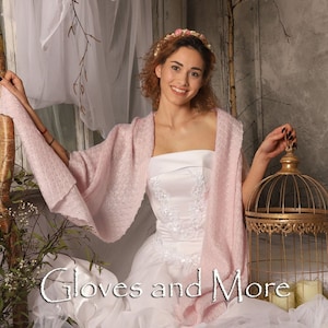 May include: A woman wearing a white strapless dress with a pink shawl and a flower crown. She is holding a gold birdcage. The text "Gloves and More" is visible in the image.