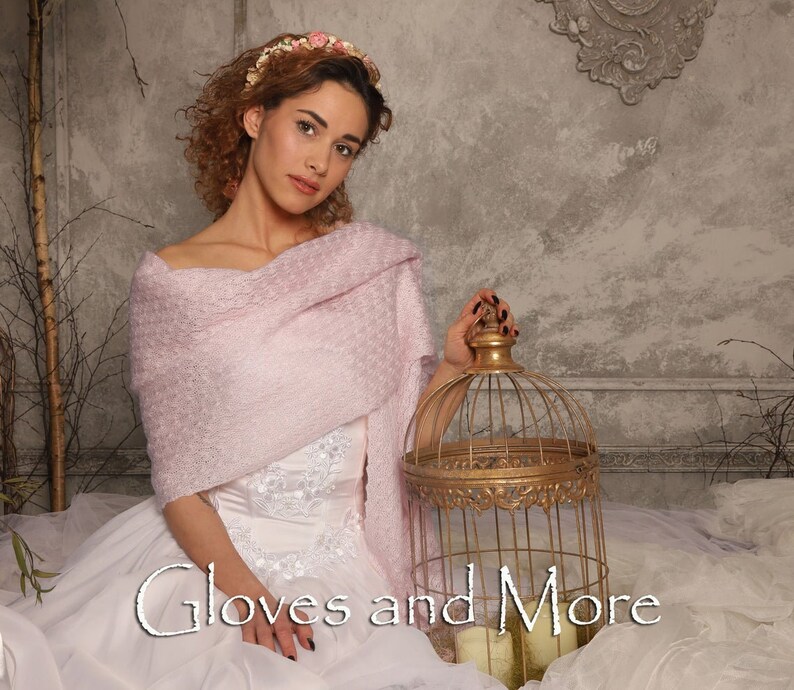 May include: A woman wearing a pink knitted shawl and a white dress with floral embroidery, holding a gold birdcage. The text "Gloves and More" is written in white on a white background.