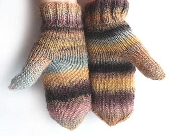 Può includere: Un paio di guanti lavorati a maglia in una varietà di colori, tra cui marrone, giallo, blu e rosa. I guanti sono realizzati con un filato morbido e strutturato e hanno un polsino a coste. Sono progettati per tenere le mani al caldo.