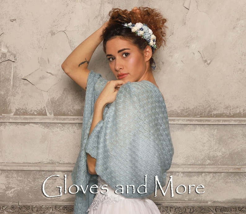 May include: A woman wearing a light blue knitted shawl with a floral headband. The text "Gloves and More" is visible at the bottom of the image.
