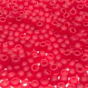 Könnte beinhalten: Nahaufnahme eines Haufens kleiner, runder, roter Perlen. Die Perlen sind undurchsichtig und haben eine matte Oberfläche.