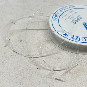 Puede incluir: Una bobina de cord&oacute;n el&aacute;stico transparente, 100% nylon, tama&ntilde;o 0,7, para la elaboraci&oacute;n de joyas.