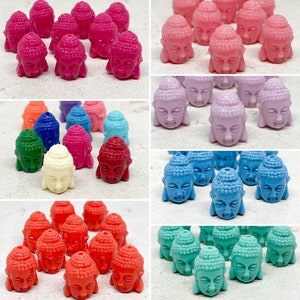 Könnte beinhalten: Sortiment an bunten Buddha-Kopfperlen in verschiedenen Farben wie Pink, Blau, Grün, Rot und Weiß. Die Perlen sind aus Kunststoff und haben eine glatte, glänzende Oberfläche.