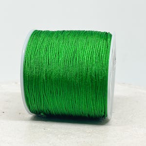 May include: A spool of bright green waxed cord, ideal for jewellery making or crafts.