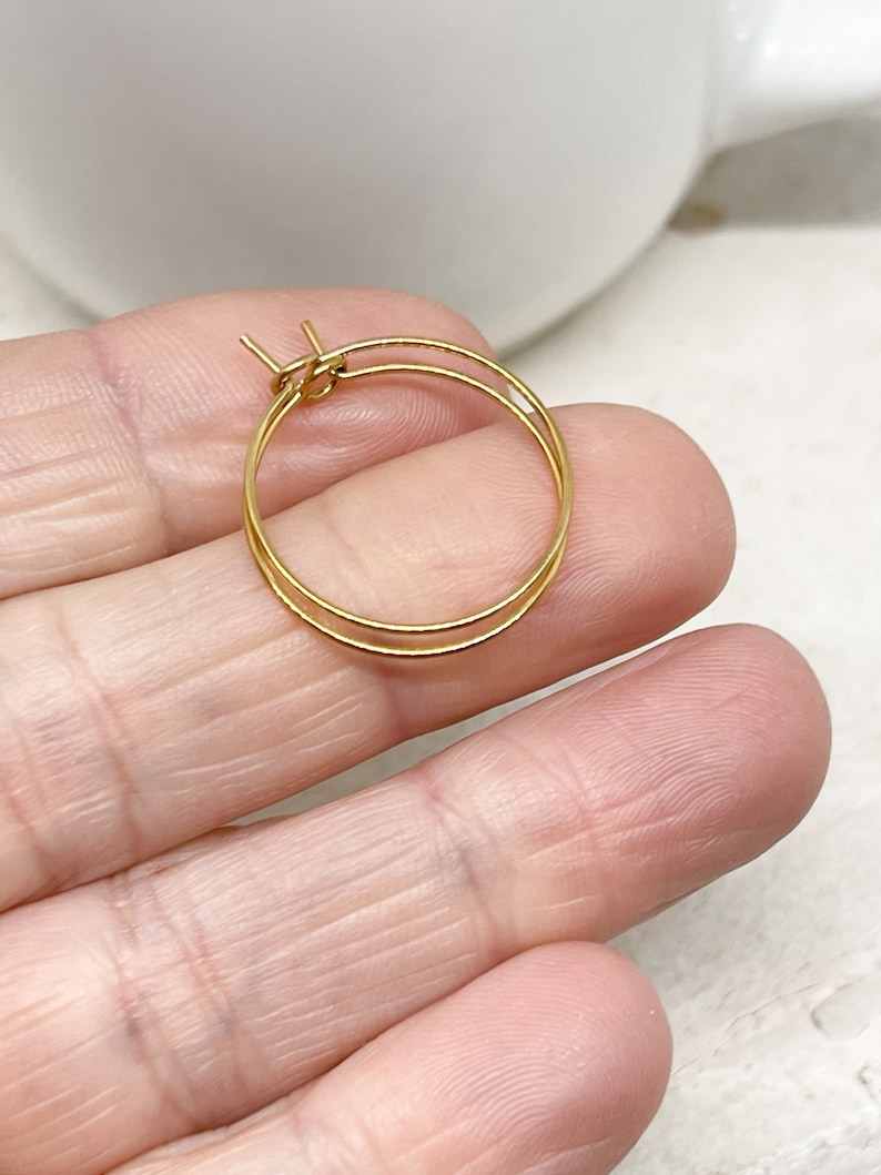May include: A pair of gold hoop earrings. The earrings are small and delicate, and they are perfect for everyday wear.