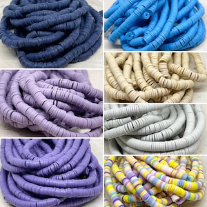 Könnte beinhalten: Sortiment an bunten Polymer Clay Perlen in verschiedenen Farben, darunter Blau, Lila, Helllila, Creme, Grau und Mehrfarbig. Die Perlen sind rund und flach, mit einem Loch in der Mitte.