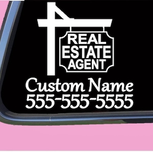 May include: White vinyl decal of a real estate sign with the text "REAL ESTATE AGENT" and space for a custom name and phone number. The decal is on a black background.