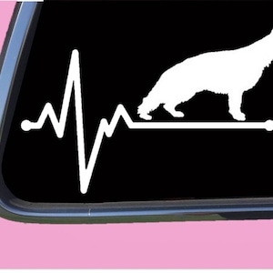 May include: White silhouette of a German Shepherd dog with a heartbeat line behind it. The image is on a black background.
