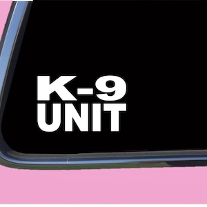 May include: White vinyl decal with the text "K-9 UNIT" on a black background.