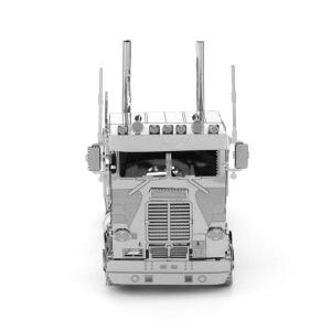 Op de afbeelding: Een zilverkleurig metalen model van een vrachtwagen, van voren gezien. De vrachtwagen heeft gedetailleerde kenmerken zoals een grille, koplampen, uitlaatpijpen en zijspiegels. Het model staat tegen een witte achtergrond.
