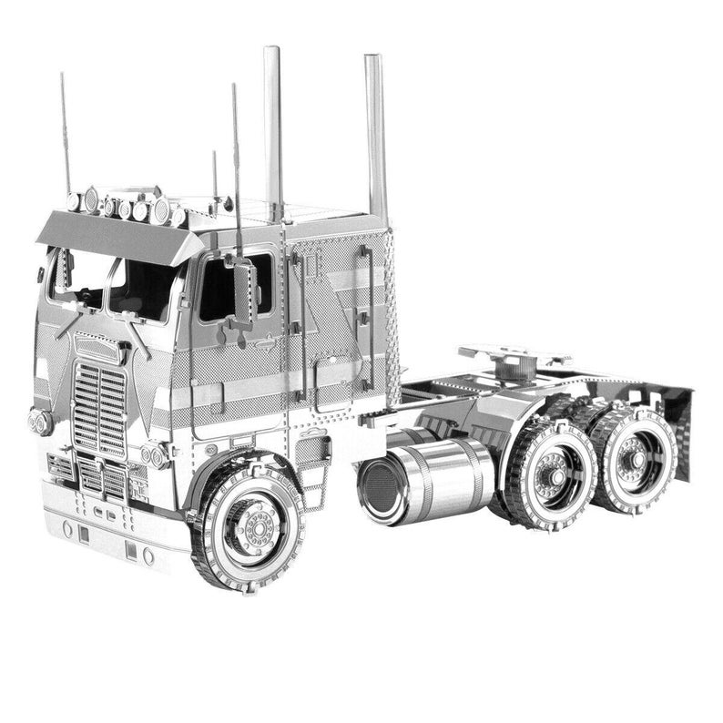 Op de afbeelding: Een zilverkleurig metalen model van een vrachtwagen. Het model heeft een gedetailleerde constructie, inclusief de cabine, de trailerkoppeling en meerdere wielen. Het model heeft een gedetailleerde grille, koplampen en uitlaatpijpen. Het model is een verzamelobject.