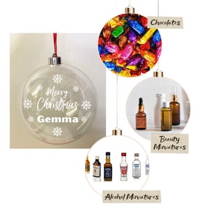 May include: Clear Christmas bauble with the text "Merry Christmas Gemma" and snowflakes.  Three other baubles are shown with different contents: chocolates, beauty miniatures, and alcohol miniatures.