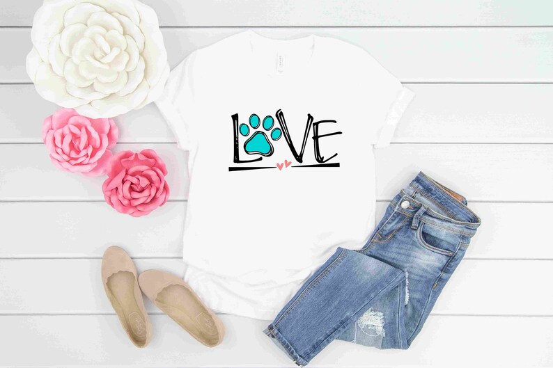 May include: White t-shirt with a black and white graphic of the word "LOVE" with a blue paw print in the "O".