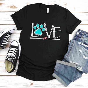 May include: Black t-shirt with a white graphic that says "LOVE" with a blue paw print in the "O". There are two small pink hearts under the word "LOVE".