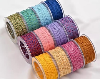May include: A collection of colorful spools of cord in various shades, including blue, green, pink, and yellow. The cords are tightly wound on clear plastic spools, showcasing their texture and color variations. Ideal for crafting and jewelry making.