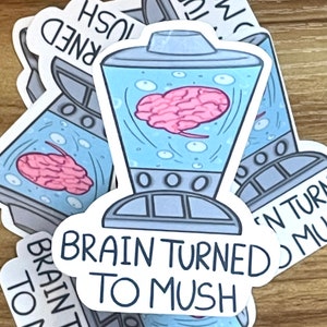 May include: A sticker with a cartoon blender with a pink brain inside. The text on the sticker reads "Brain Turned To Mush".