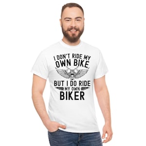 May include: White t-shirt with black text that reads "I don't ride my own bike but I do ride my own biker" with a motorcycle graphic.
