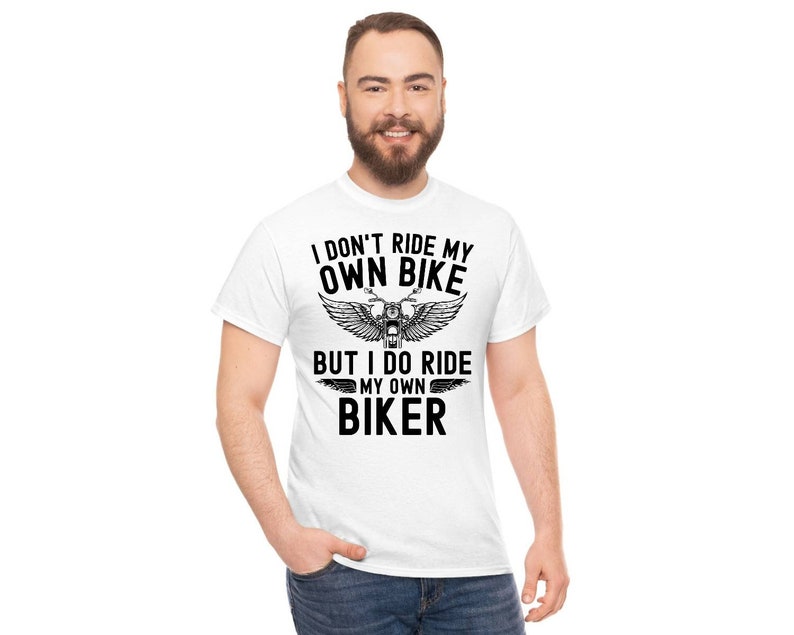 May include: White t-shirt with black text that reads "I don't ride my own bike but I do ride my own biker" with a motorcycle graphic.