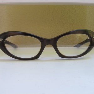 Op de afbeelding: Een paar bruine cat-eye brillen met heldere glazen.